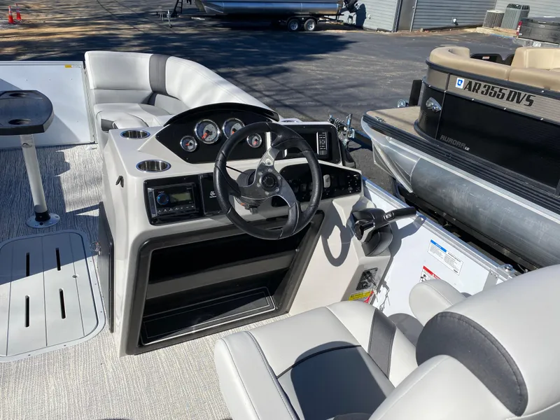 Slide: The Image of 2025 SunCatcher Select 322RC boat interior with steering wheel and seating area. - 10