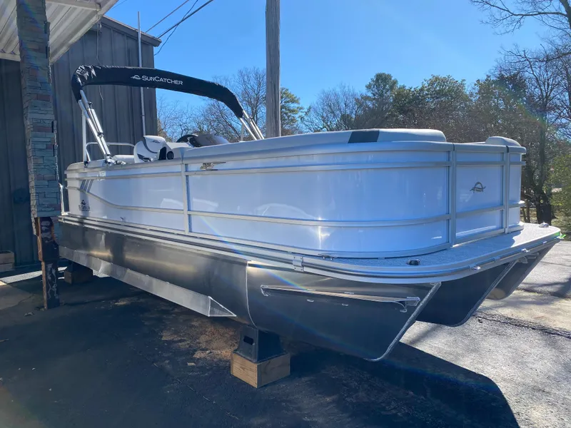 Slide: The Image of 2025 SunCatcher Select 322RC pontoon boat, white exterior, parked outdoors on a sunny day. - 3