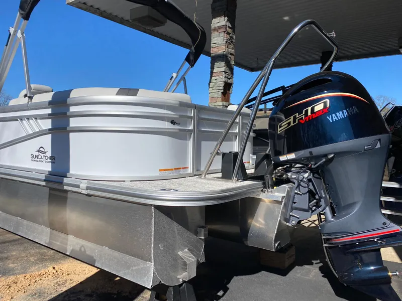 Slide: The Image of 2025 SunCatcher Select 322RC pontoon boat with Yamaha outboard motor, docked under a canopy. - 4