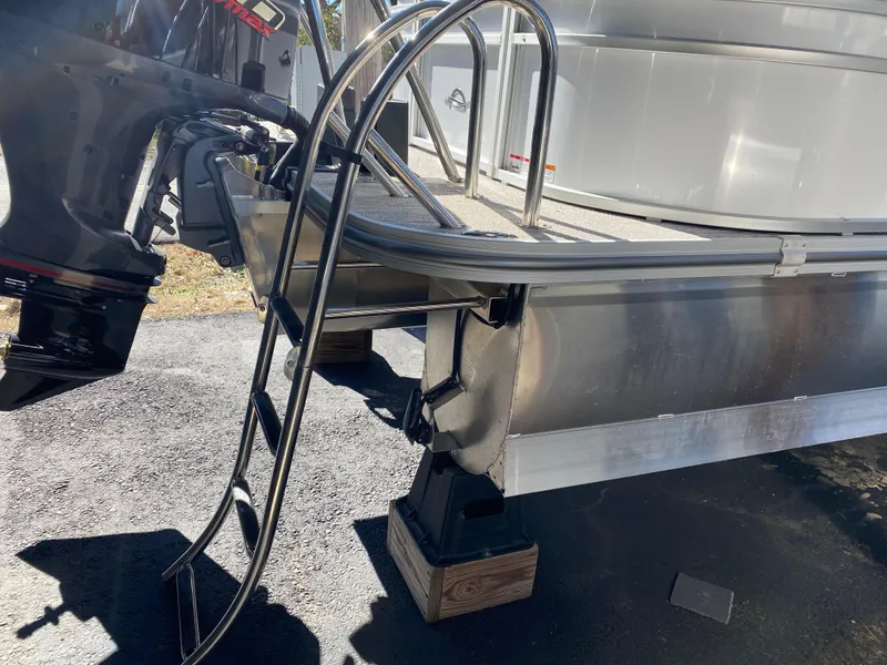 Slide: The Image of 2025 SunCatcher Select 322RC boat with ladder and motor, displayed on a stand. - 6