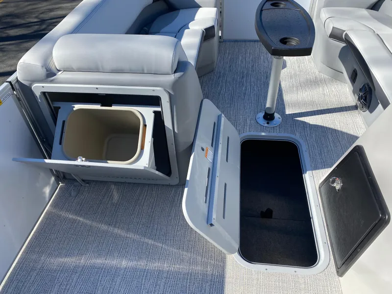 Slide: The Image of 2025 SunCatcher Select 322RC boat interior with storage compartments and seating. - 8