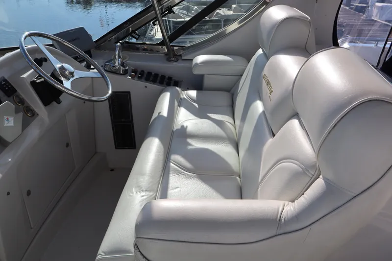 Slide: The Image of Luxurious helm seating on 2006 Bluewater Yachts 5200, featuring plush white leather upholstery. - 10