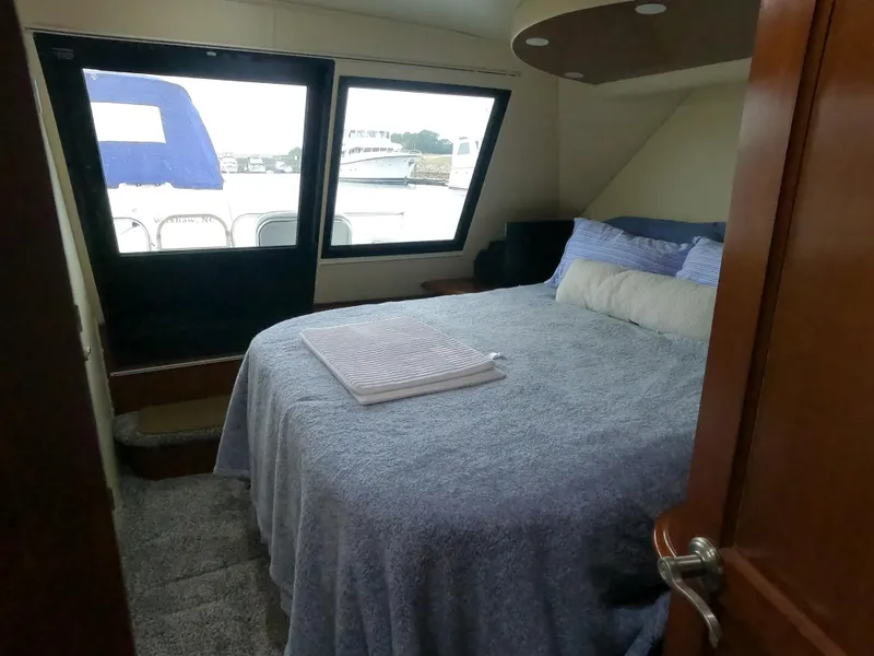Slide: The Image of Bedroom interior of 2006 Bluewater Yachts 5200 with large bed and window view. - 19
