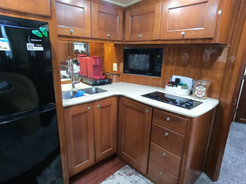 Slide: The Image of Kitchen area of 2006 Bluewater Yachts 5200 with wood cabinets and modern appliances. - 25