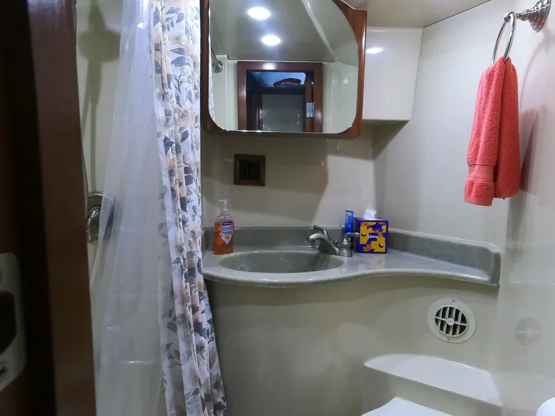 Slide: The Image of Bathroom interior of 2006 Bluewater Yachts 5200 with sink, mirror, and shower curtain. - 32