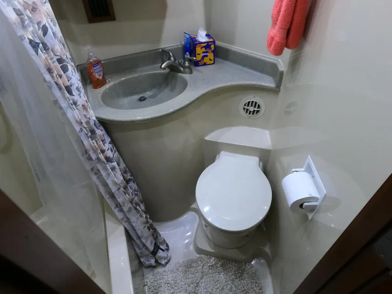 Slide: The Image of Compact bathroom in 2006 Bluewater Yachts 5200, featuring sink, toilet, and shower area. - 33