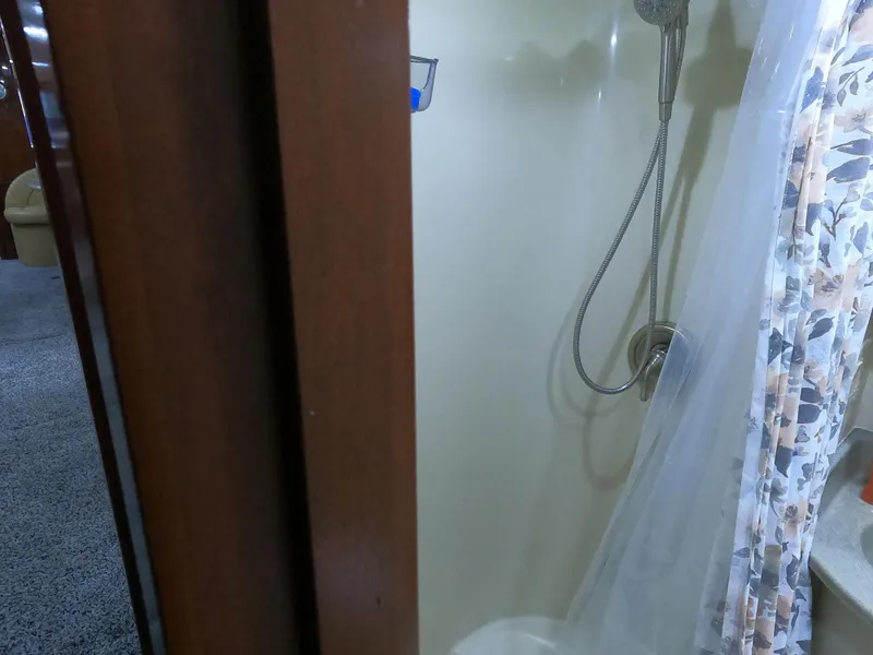 Slide: The Image of Shower area inside 2006 Bluewater Yachts 5200, featuring a handheld showerhead and curtain. - 34