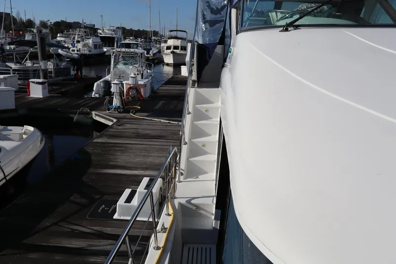 Slide: The Image of 2006 Bluewater Yachts 5200 docked at marina, side view with stairs and railing. - 4