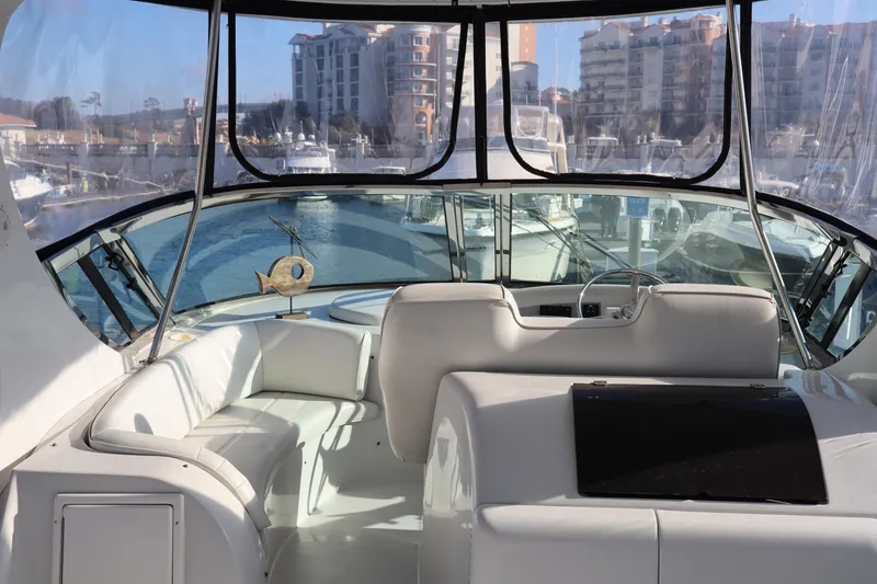 Slide: The Image of Interior view of 2006 Bluewater Yachts 5200, featuring a spacious cockpit and marina backdrop. - 6