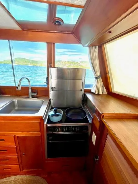 Slide: The Image of 1986 Grand Banks 42 Classic yacht kitchen with stove, sink, and ocean view. - 13