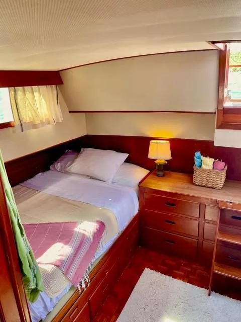 Slide: The Image of Cozy cabin interior of 1986 Grand Banks 42 Classic with bed, lamp, and wooden furnishings. - 19