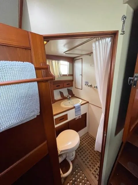 Slide: The Image of 1986 Grand Banks 42 Classic yacht bathroom with wooden accents and compact design. - 23