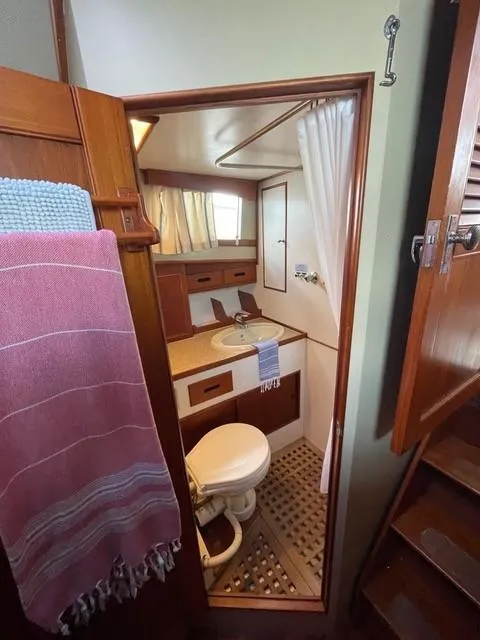 Slide: The Image of 1986 Grand Banks 42 Classic yacht bathroom with wooden cabinetry and nautical decor. - 24