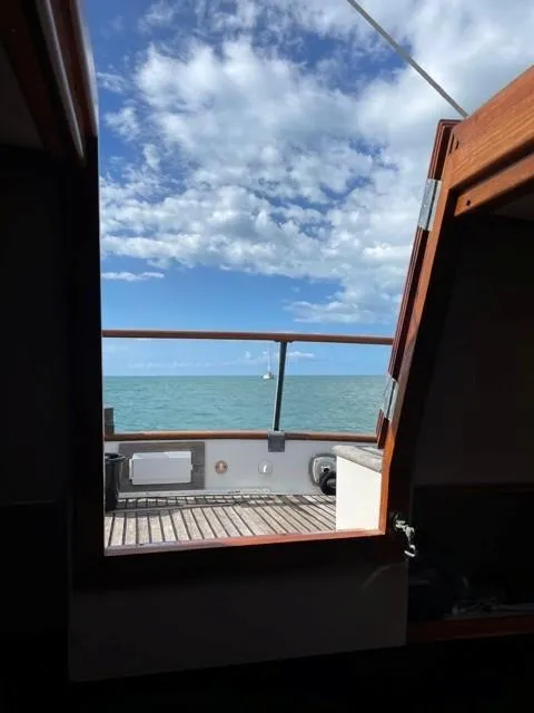 Slide: The Image of View from 1986 Grand Banks 42 Classic yacht, open door to ocean and sky. - 25