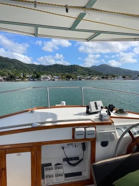 Slide: The Image of 1986 Grand Banks 42 Classic yacht with scenic coastal view and mountains in the background. - 28
