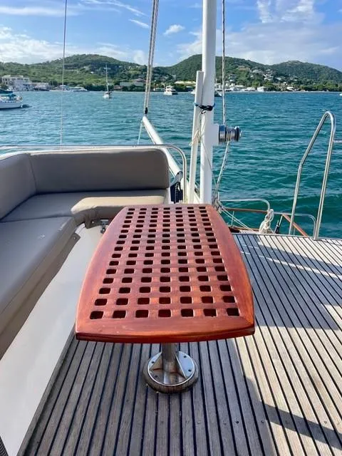 Slide: The Image of 1986 Grand Banks 42 Classic yacht deck with wooden table, scenic ocean view. - 30