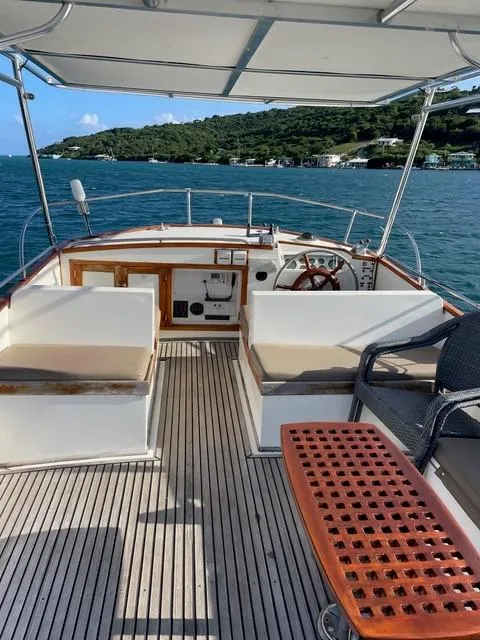 Slide: The Image of 1986 Grand Banks 42 Classic yacht interior with seating, steering wheel, and ocean view. - 31