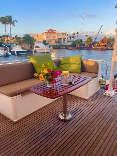 Slide: The Image of Grand Banks 42 Classic 1986 yacht deck with seating, table, and vibrant flowers. - 32