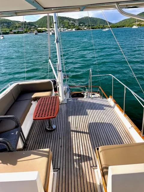 Slide: The Image of 1986 Grand Banks 42 Classic yacht deck with seating, table, and scenic water view. - 34