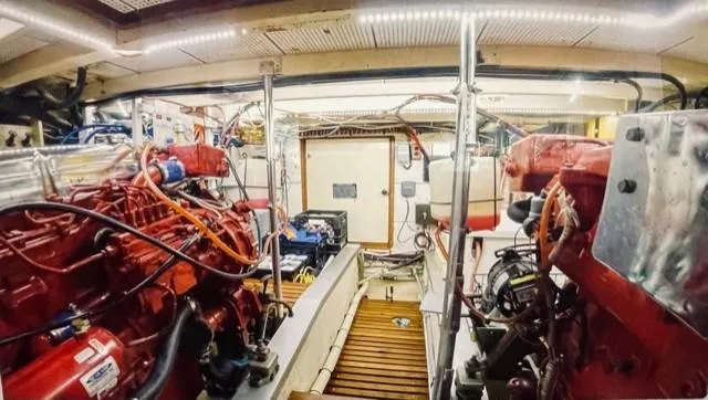 Slide: The Image of Engine room of 1986 Grand Banks 42 Classic yacht, featuring dual red engines and organized wiring. - 42