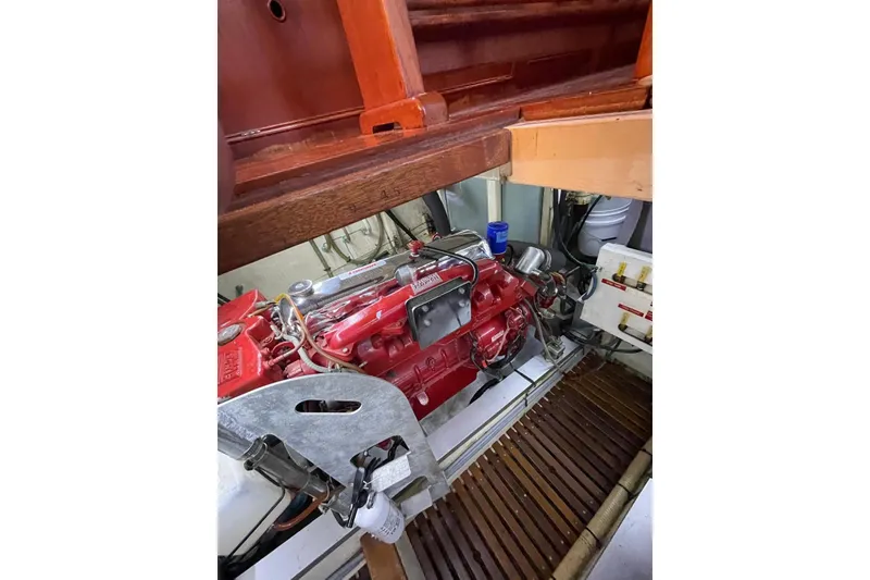 Slide: The Image of Engine room of 1986 Grand Banks 42 Classic with red engine and wooden flooring. - 43
