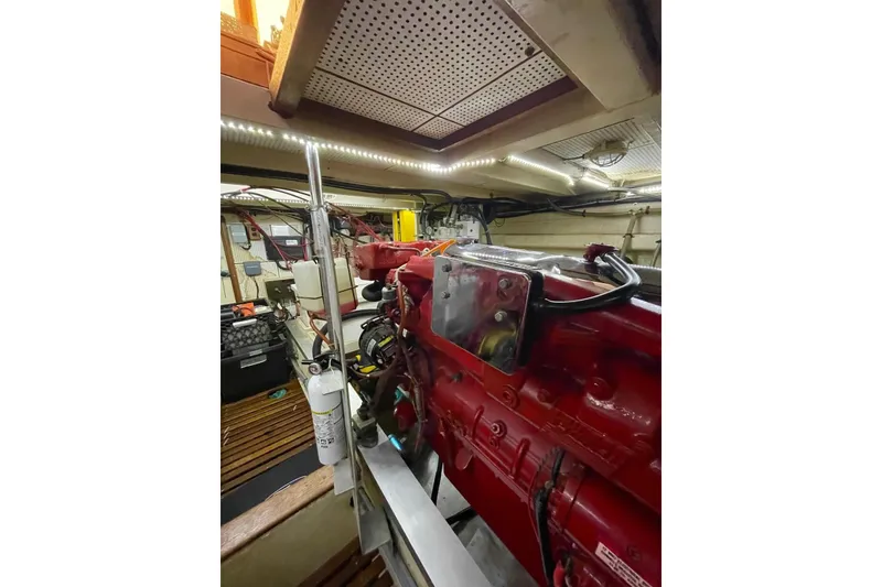 Slide: The Image of Engine room of 1986 Grand Banks 42 Classic yacht, featuring red machinery and organized layout. - 45