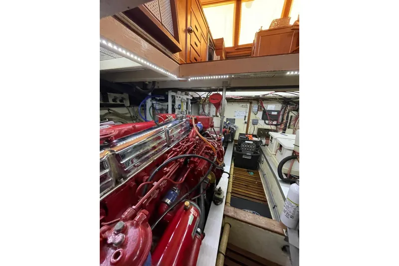 Slide: The Image of Engine room of 1986 Grand Banks 42 Classic yacht, featuring red engine and organized layout. - 48