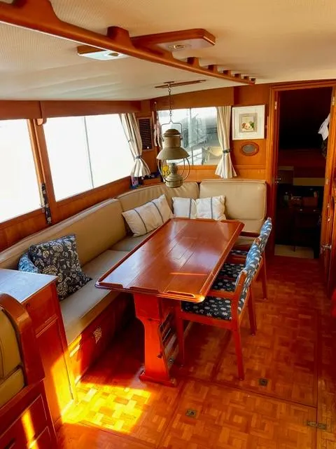 Slide: The Image of 1986 Grand Banks 42 Classic interior with wooden dining area and cushioned seating. - 5