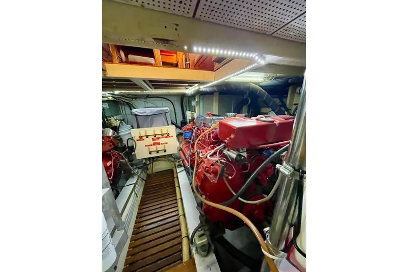 Slide: The Image of Engine room of 1986 Grand Banks 42 Classic yacht with red machinery and control panel. - 54