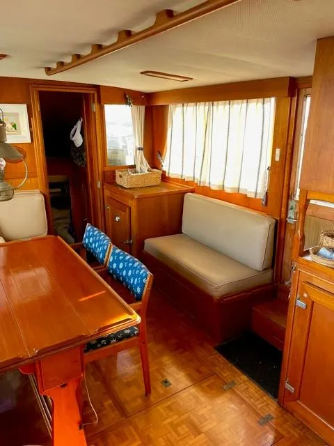 Slide: The Image of 1986 Grand Banks 42 Classic interior with wooden furnishings and cozy seating area. - 7