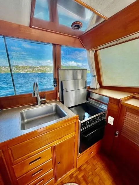 Slide: The Image of 1986 Grand Banks 42 Classic yacht kitchen with wood cabinetry, stainless steel sink, and ocean view. - 9