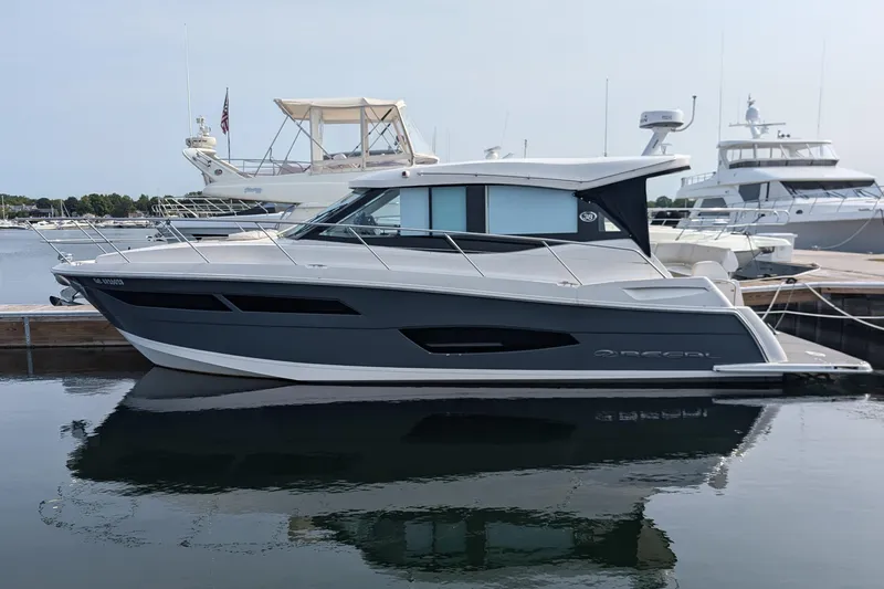 The Image of 2020 Regal 38 Grande Coupe yacht docked at marina, sleek design, calm water reflection. - 0