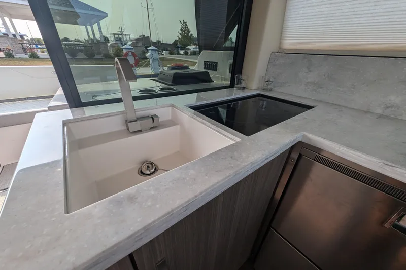 Slide: The Image of Modern kitchen area in a 2020 Regal 38 Grande Coupe yacht with sink and stovetop. - 11
