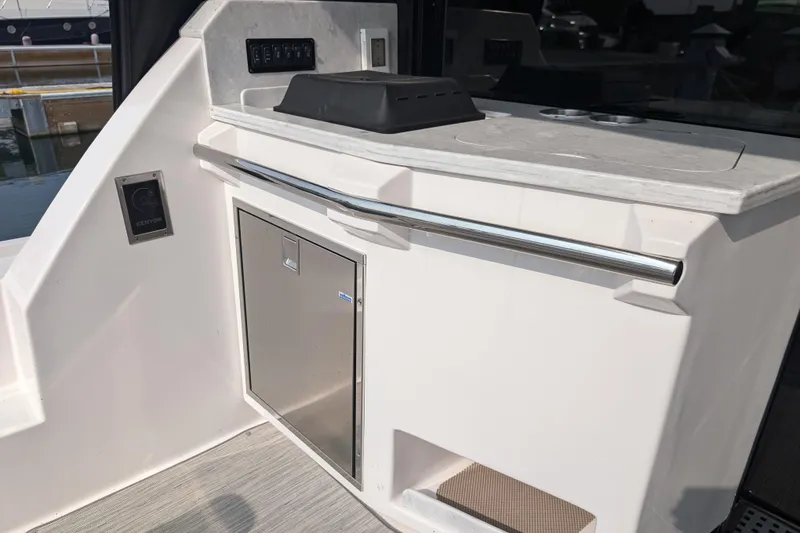 Slide: The Image of 2020 Regal 38 Grande Coupe yacht interior with sleek kitchenette and stainless steel accents. - 7