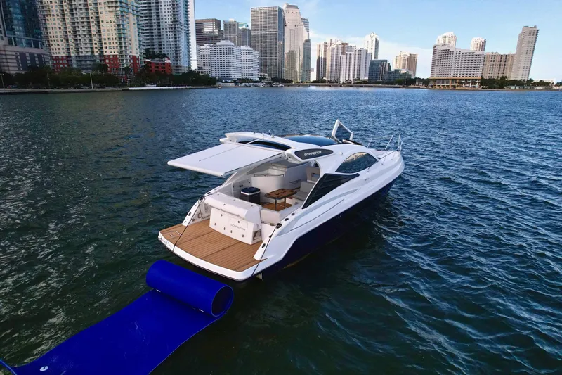 Slide: The Image of Luxury Schaefer 375 yacht on water, city skyline in background, 2023 model. - 2