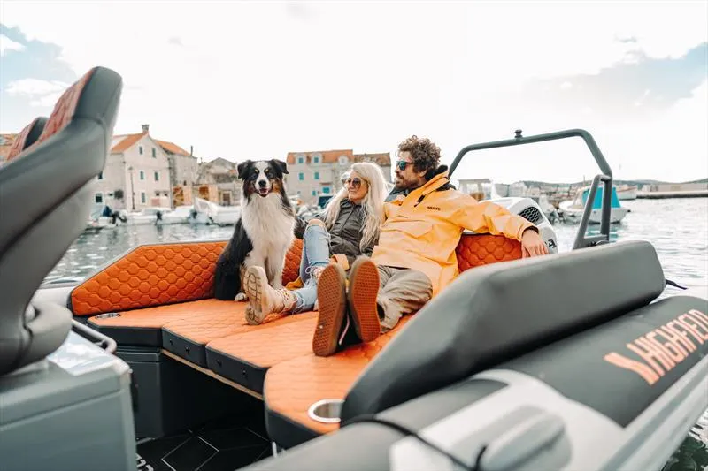 Slide: The Image of Couple and dog relaxing on 2025 Highfield ADV7 boat in scenic harbor. - 5