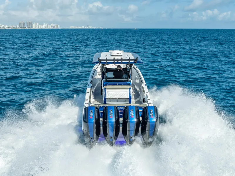 The Image of 2024 Nor-Tech 390 Sport boat cruising on open ocean with four powerful engines. - 1