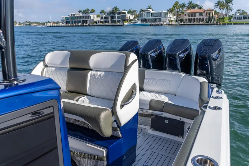 Slide: The Image of 2024 Nor-Tech 390 Sport boat with luxurious seating and powerful engines on a scenic waterfront. - 10