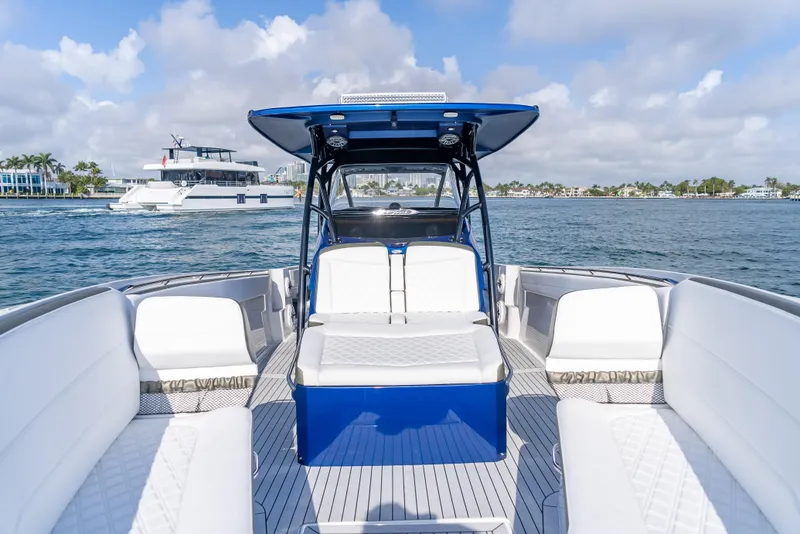 Slide: The Image of 2024 Nor-Tech 390 Sport boat interior with white seating on a sunny day. - 26
