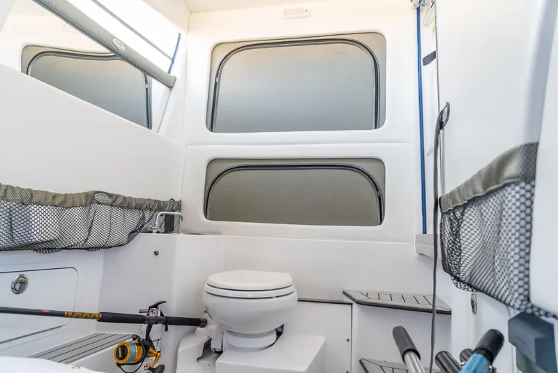 Slide: The Image of 2024 Nor-Tech 390 Sport interior cabin with toilet and fishing gear storage. - 28