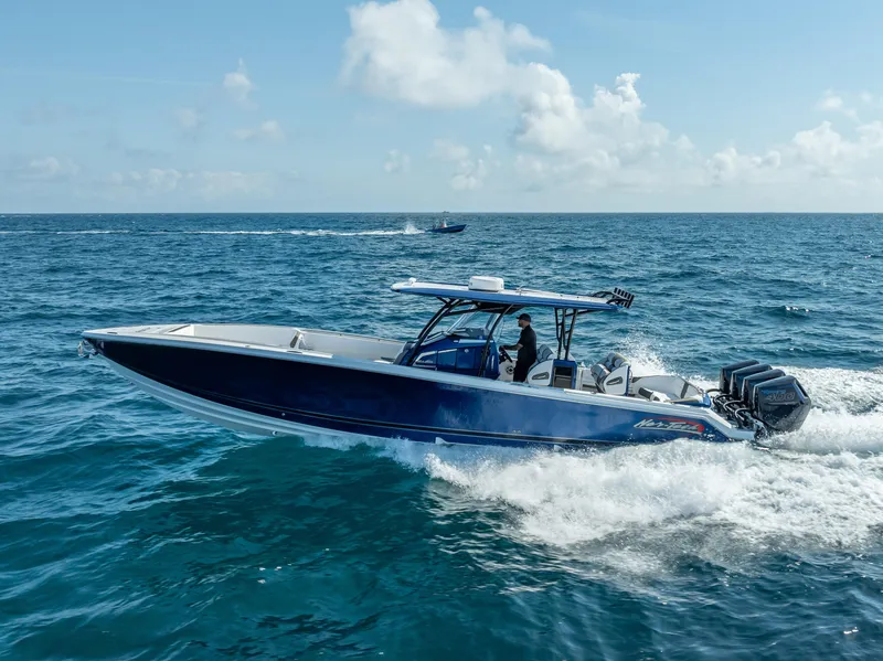 Slide: The Image of 2024 Nor-Tech 390 Sport boat cruising on open ocean under clear skies. - 31