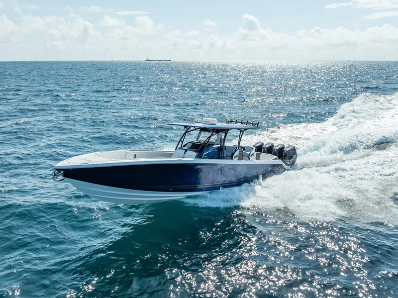 Slide: The Image of 2024 Nor-Tech 390 Sport boat cruising on open ocean under clear skies. - 32