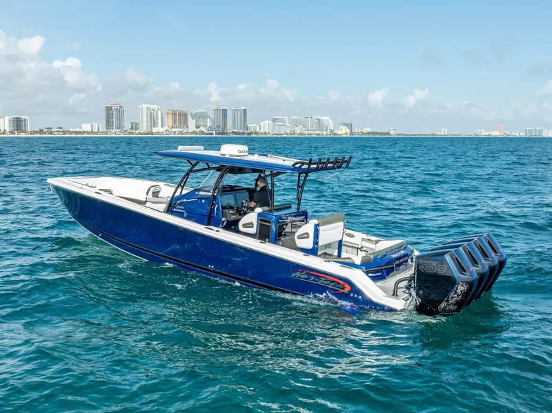 Slide: The Image of 2024 Nor-Tech 390 Sport boat cruising on blue ocean near city skyline. - 41