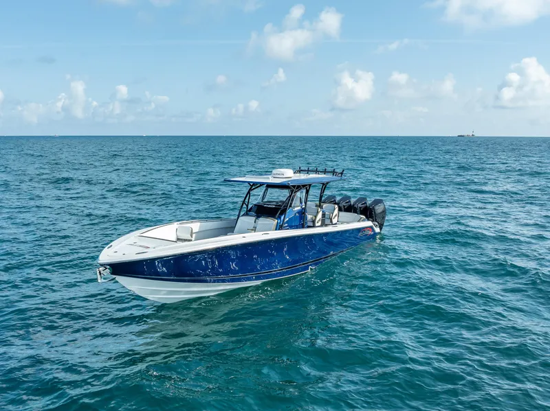 Slide: The Image of 2024 Nor-Tech 390 Sport boat cruising on open ocean under clear skies. - 44