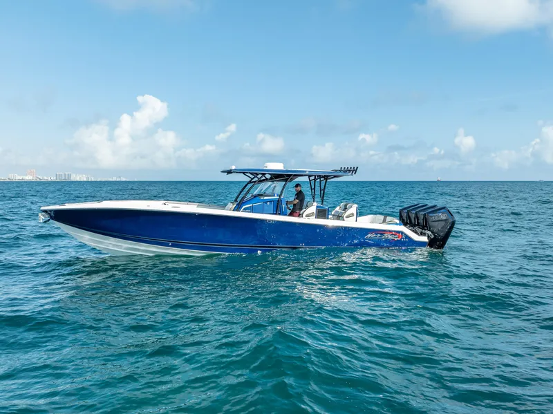 Slide: The Image of 2024 Nor-Tech 390 Sport boat cruising on open water under a clear blue sky. - 6
