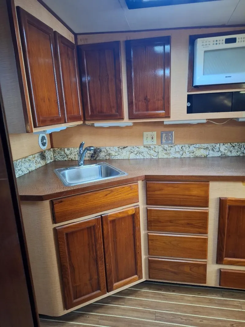 Slide: The Image of 1970 Hatteras 45 Sportfish kitchen with wooden cabinets and modern appliances. - 15