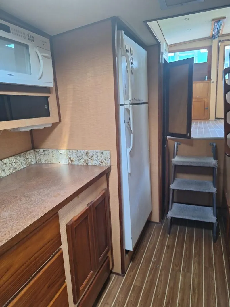 Slide: The Image of 1970 Hatteras 45 Sportfish interior kitchen with wood cabinets and modern appliances. - 16