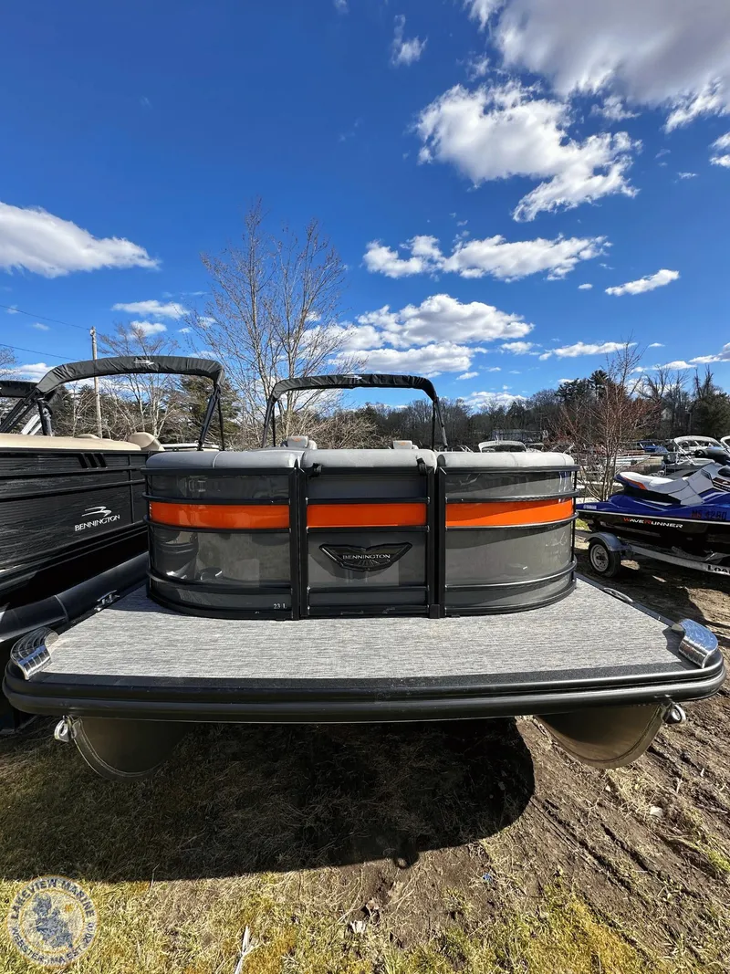 Slide: The Image of 2024 Bennington 23 LSR pontoon boat, rear view, under a clear blue sky. - 1