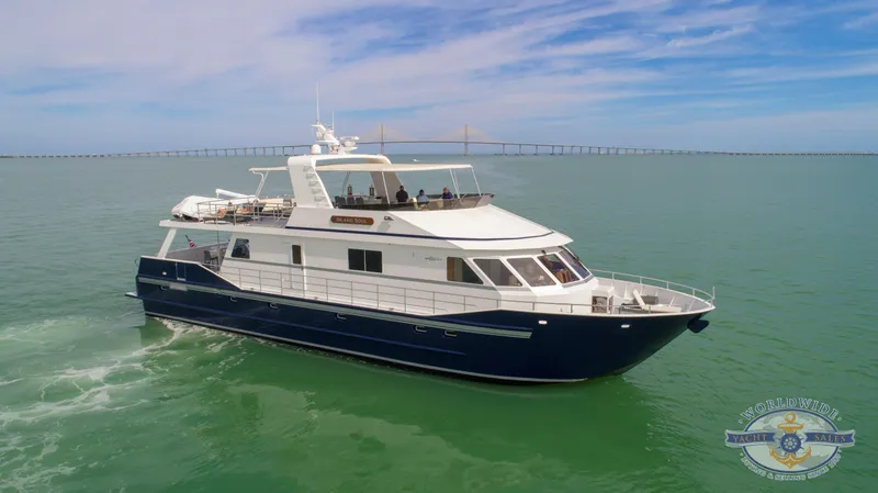 Slide: The Image of Custom 2009 Flybridge Motoryacht cruising on open water with bridge in background. - 1