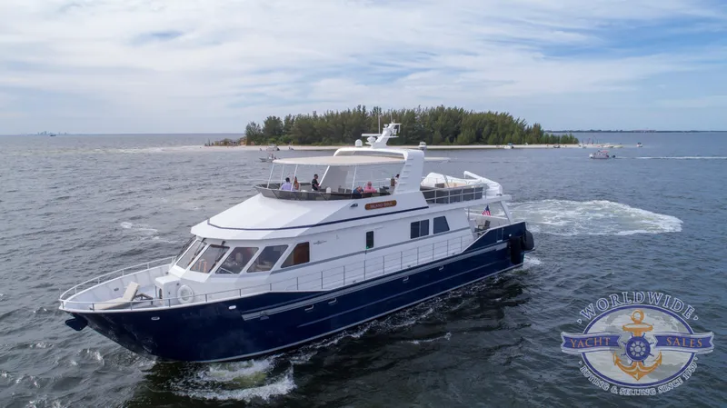 Slide: The Image of Custom 2009 Flybridge Motoryacht cruising near an island, open water, Worldwide Yacht Sales logo. - 4